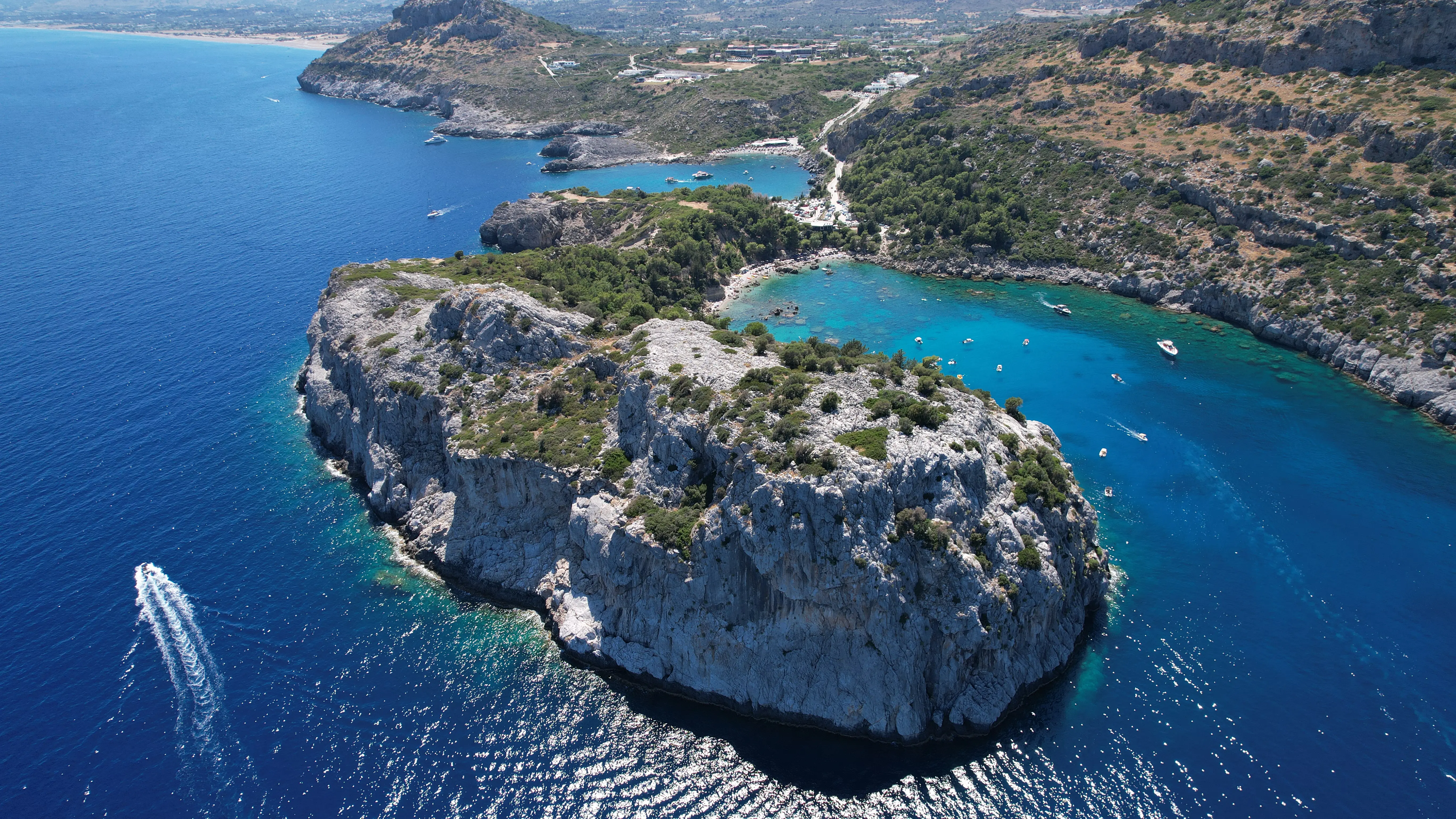 Aerial view outside Ladiko Bay with clear water and rocky coastline