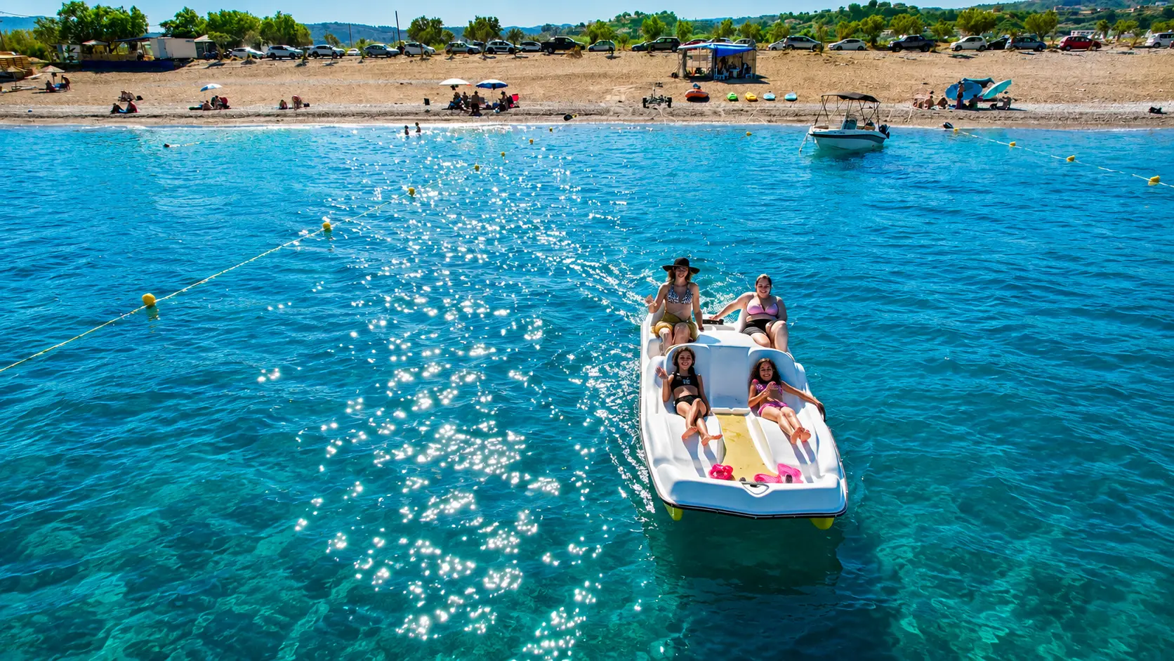 Family pedalo and paddle equipment beside the Riptide kiosk at Afandou Beach